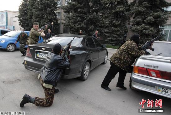 当地时间4月29日下午，武装的乌克兰亲俄抗议者在汽车后掩护，准备向甘斯克州警察总部发起冲击。
