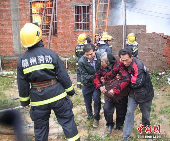 江西赣州民房发生火灾 消防员营救被困老人(图)