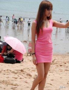 抓拍沙滩上粉色包臀裙香艳美女