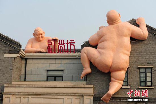 济南“佛跳墙”雕塑被拆续:再现裸身攀房雕塑(图)