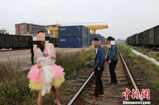 新人在铁轨上拍婚纱照逼停火车 被警方处罚(图)