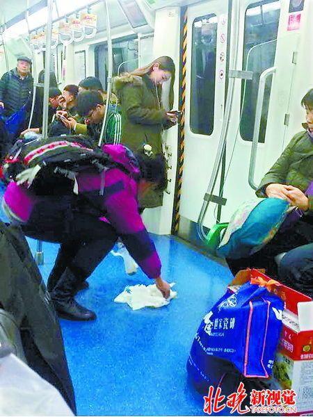 北京地铁乘客晕车呕吐离开 大姐俯身擦净秽物