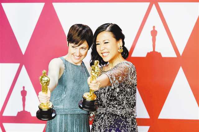 二月二十四日，在美国洛杉矶杜比剧院，获得最佳动画短片奖的《包宝宝》的导演石之予（右）展示奖杯。新华社记者 李颖 摄