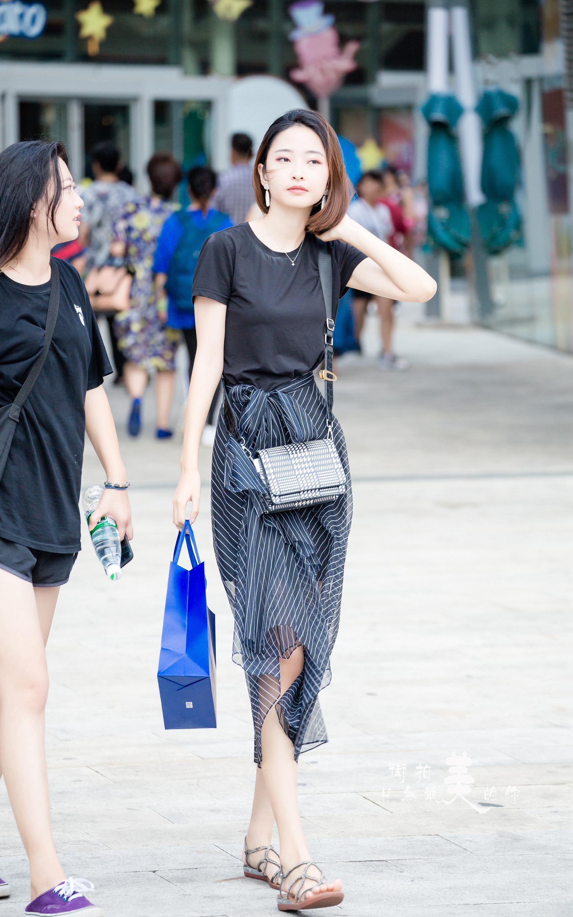 购物广场轻撩头发的气质美女 黑色短袖加黑色透视裙,