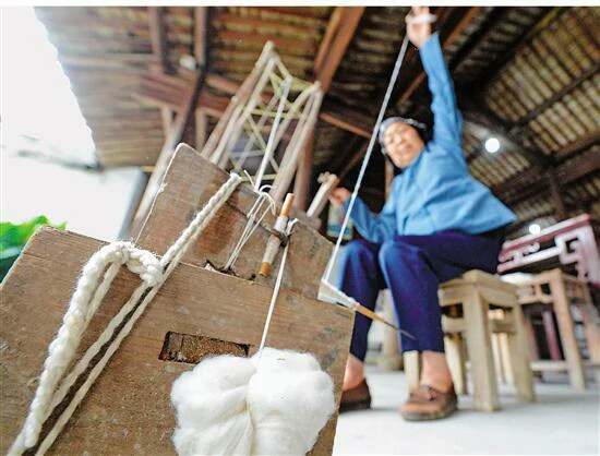 77岁的朱去宝纺纱动作熟练，让人依稀看到她年轻时的风采。