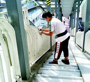1日上午正在14中门前的BRT天桥上擦拭栏杆的大公桥的小志愿者们。 记者闫承敏摄