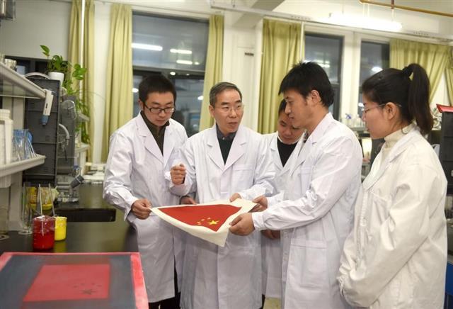 武汉纺织大学徐卫林教授（左二）和团队成员王运利、曹根阳、盛丹、潘恒研讨国旗研制技术问题