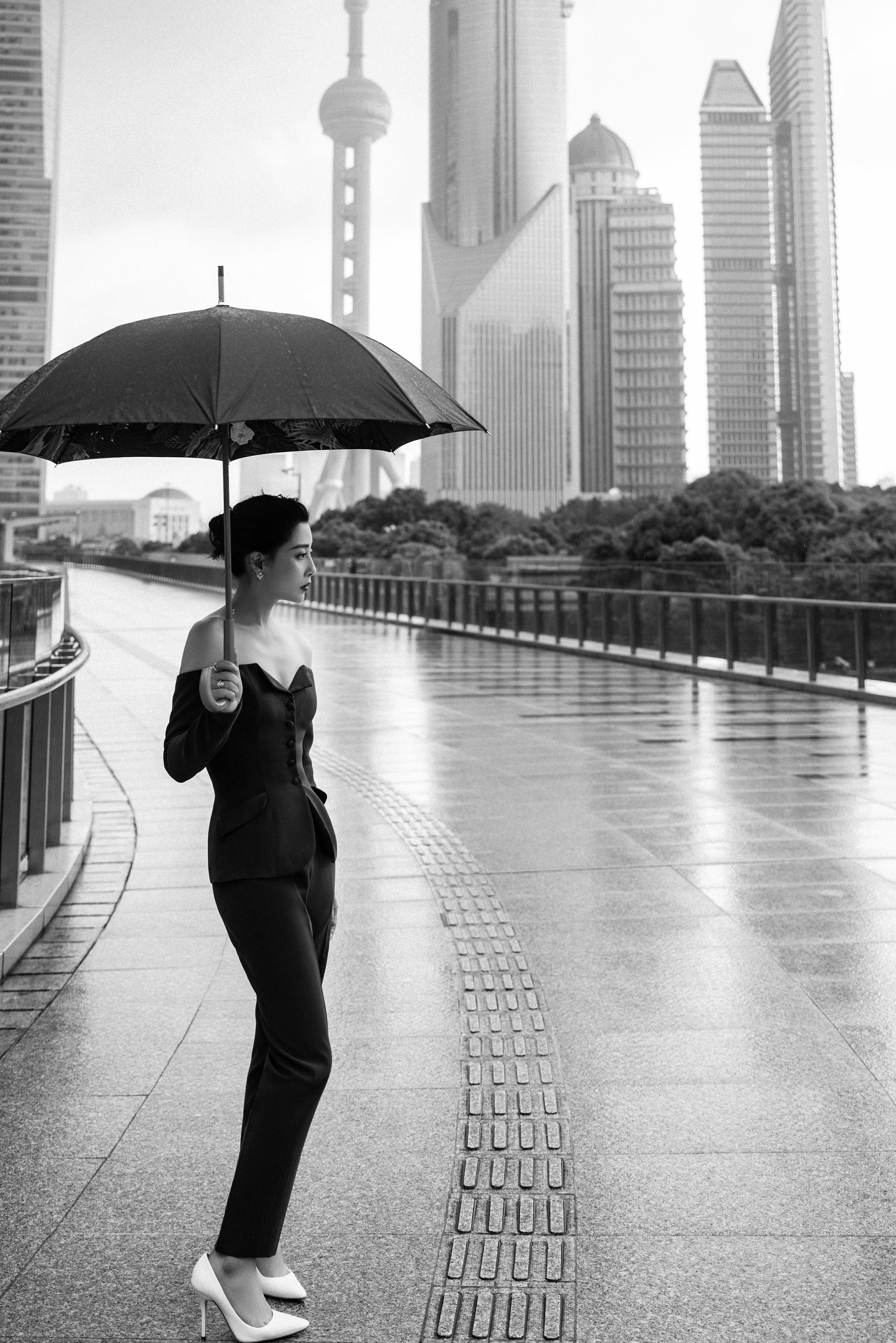 殷桃雨中撑伞漫步上海街头 一字肩西装套装潇洒利落,