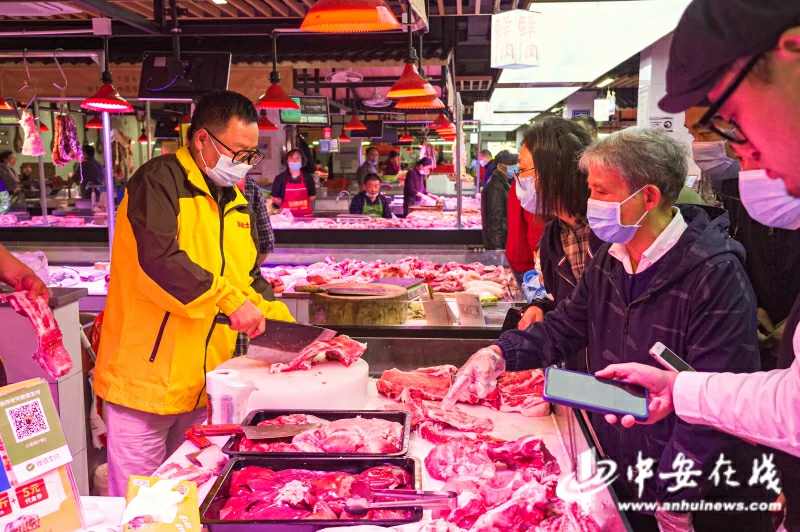 10月16日，陆步轩（左）正在合肥九华山农贸市场的档口前操刀卖肉