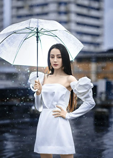 迪丽热巴白色泡泡袖抹胸裙秀美腿 撑伞伫立雨中氛围感拉满