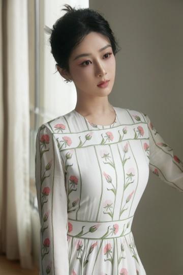 杨紫白色印花长裙盘发造型优雅动人 手持鲜花合影人比花娇
