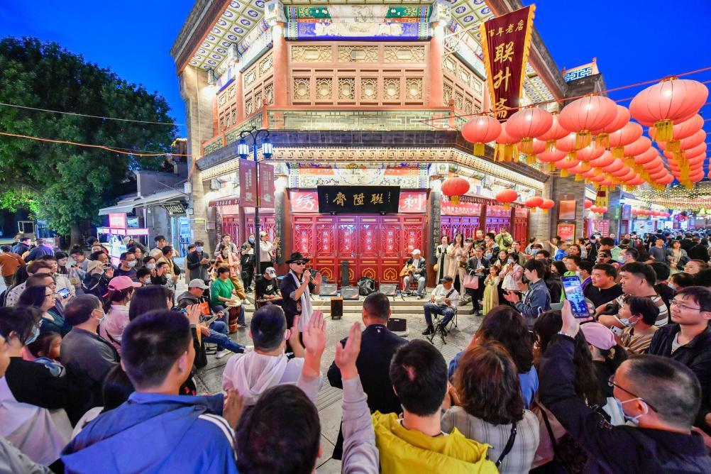 游客在天津古文化街欣赏歌手演唱。新华社记者 孙凡越 摄